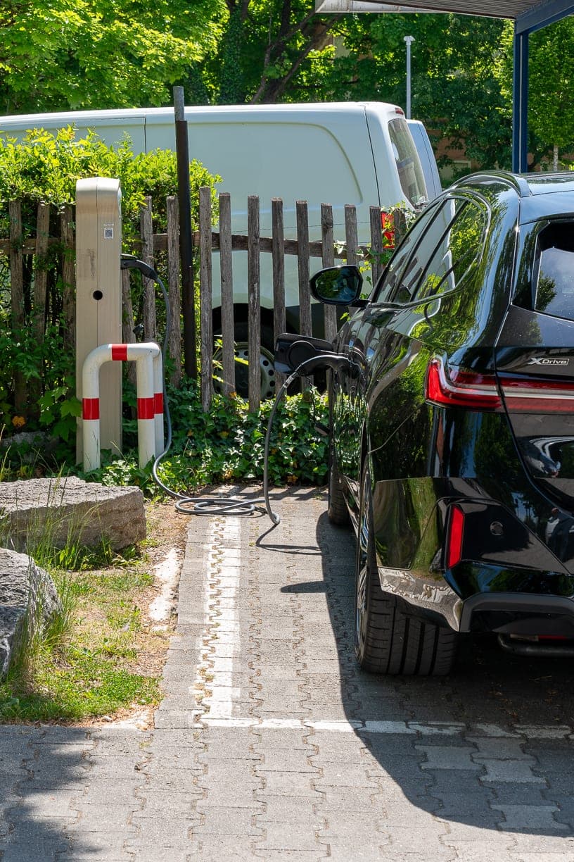Ein Elektroauto lädt mit eingestecktem Kabel an einer Ladesäule